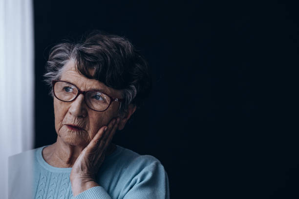 vecchia in camera oscura - senior adult depression dementia alzheimers disease foto e immagini stock