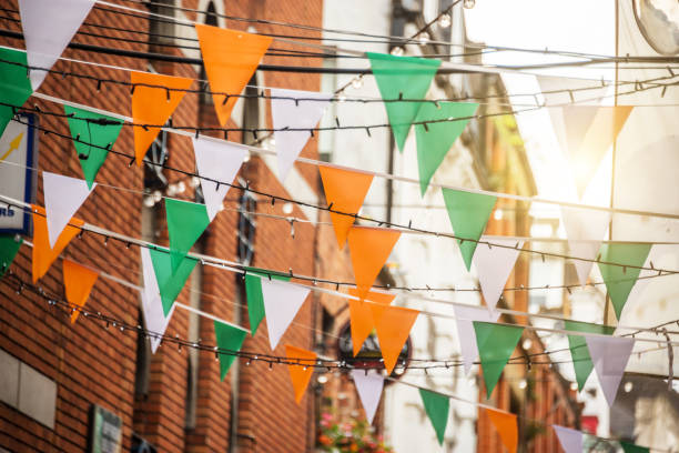 guirnalda con bandera irlandesa los colores en una calle de dublín, irlanda - concepto de celebración de día de san patricio - dublín fotografías e imágenes de stock