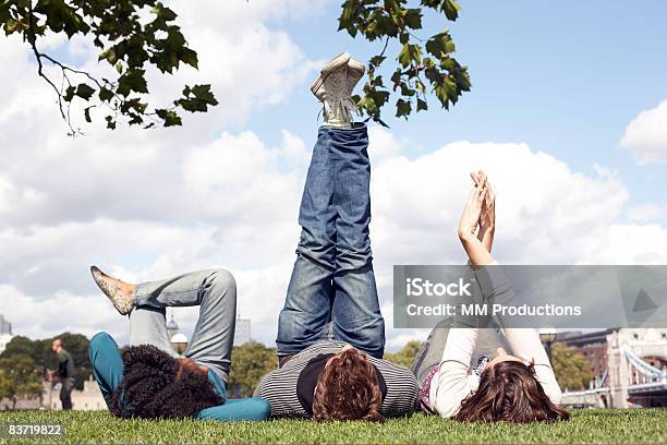 Friends Relaxing In Park Stock Photo - Download Image Now - Public Park, Friendship, Feet Up