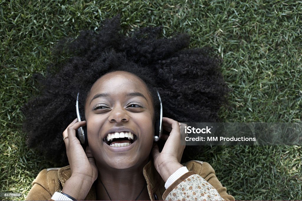 Woman listening to music lying on grass  Headphones Stock Photo