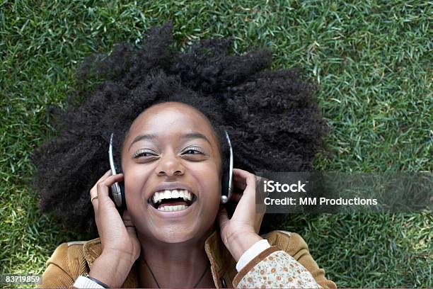 Woman Listening To Music Lying On Grass Stock Photo - Download Image Now - Headphones, Listening, Music