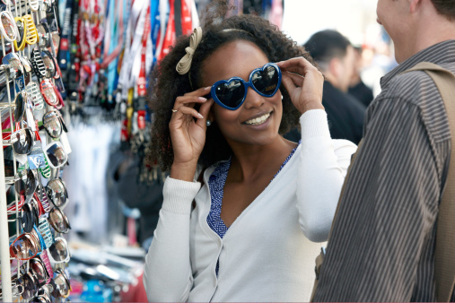 Various of colorful sun glasses in the shop display shelves. Selective focus