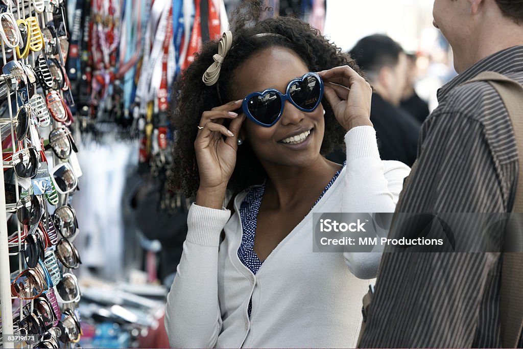 Woman trying on sunglasses with friend  Shopping Stock Photo