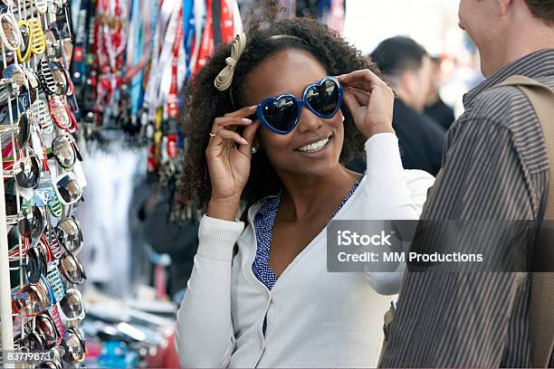 Woman Trying On Sunglasses With Friend Stock Photo - Download Image Now - Shopping, Sunglasses, Retail