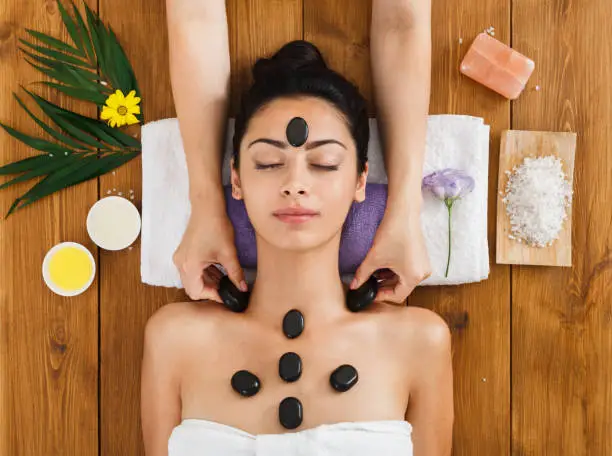 Photo of Beautician make stone massage spa for woman at wellness center