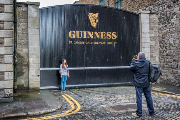 turistas toman fotos en el st james gate de la guinness cervecería de almacén. la guinness storehouse es una popular atracción turística en dublín - guinness fotografías e imágenes de stock