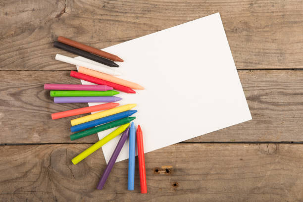 istock colored crayons and blank page on the wooden table 837259192