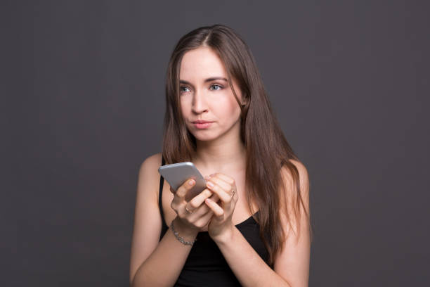 istock Pensive young woman using smartphone portrait 837266272
