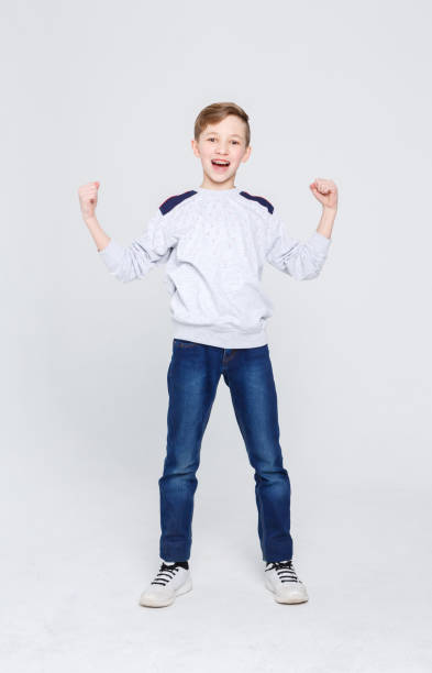 istock Portrait of cheerful boy celebrating victory at studio background 837283192