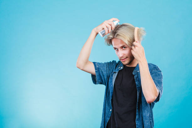 istock Man applying spray cosmetic to his hair 837284456