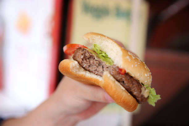 istock Beef Hamburger eating on a man hand in close up 837289986