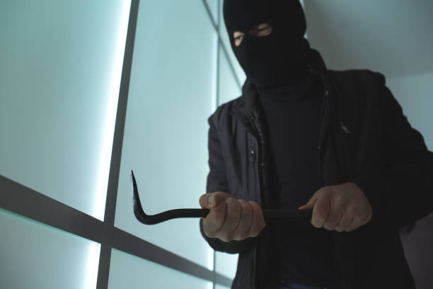 istock Burglar using a crowbar to break into a house 837290224