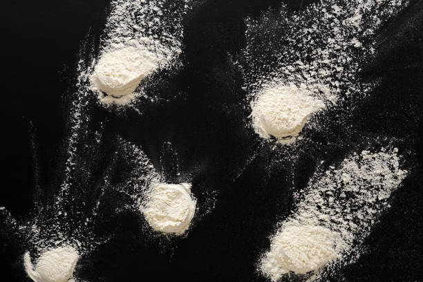 istock Sprinkled wheat flour splash spots on black background 837290970
