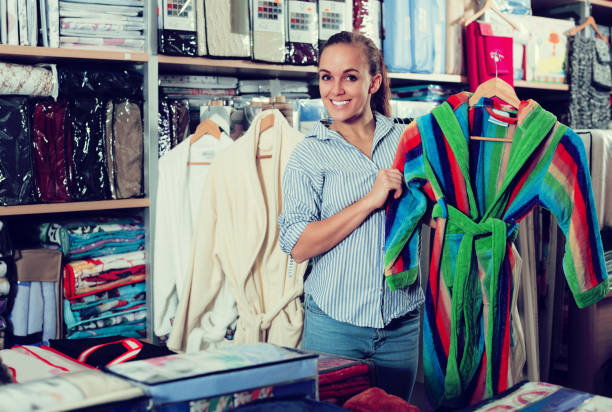 istock Young female customer looking through bathrobes 837299598