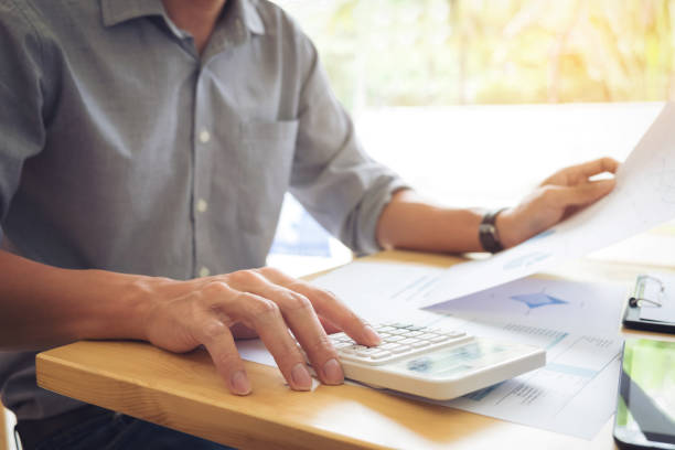 istock Business executives hands using calculator to calculate tax Invoice and set new project business strategy plan with data document at the office 837305200