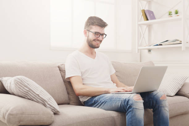 istock Young man at home messaging online on laptop 837317334