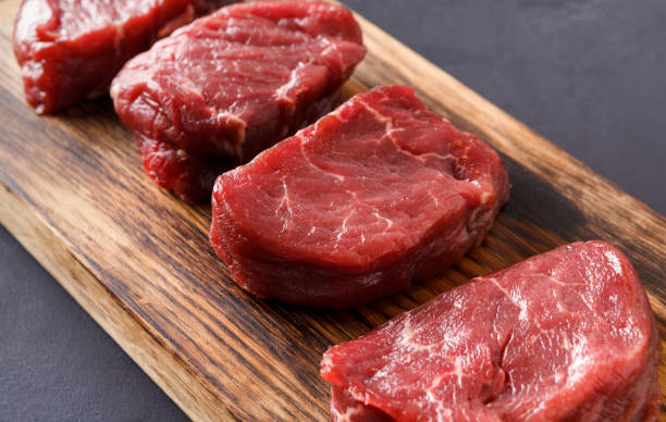 istock Raw beef filet mignon steaks on wooden board at gray background 837321100