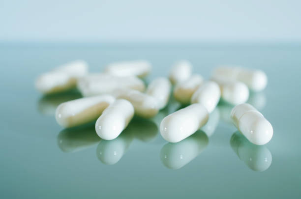 istock White medical capsules lie on the mirror surface 837322644