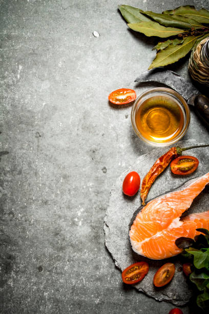 istock piece of raw trout and tomatoes. 837323358