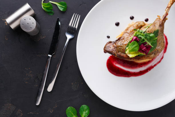 istock Restaurant meals. Duck confit with vegetables on black background 837328120
