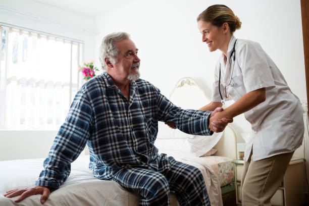 istock Female doctor assisting man in standing at nursing home 837331068