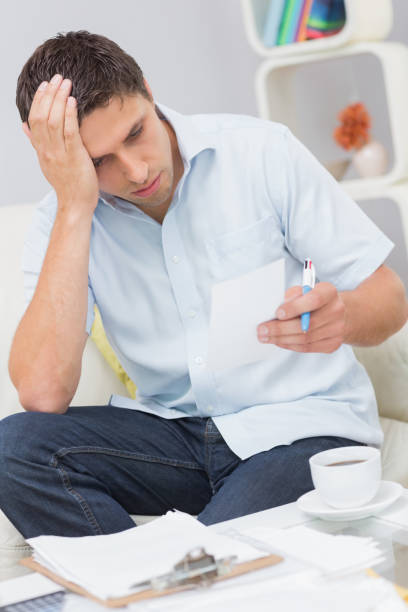istock Worried young man paying his bills at home 837335942