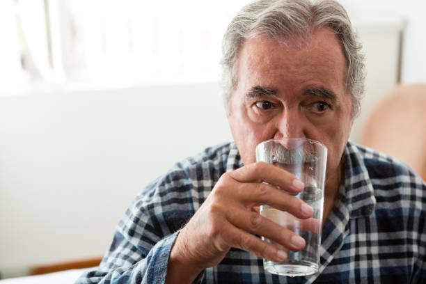 istock Senior man drinking water in nursing home 837336220