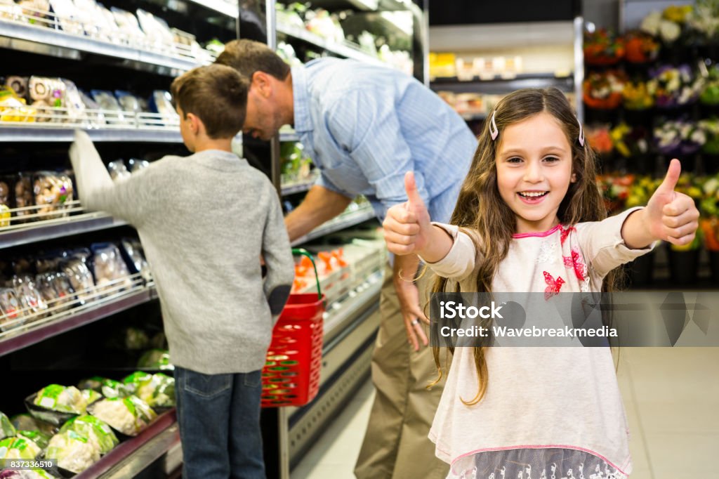 Smiling daughter with thumps up Smiling daughter with thumps up in grocery store 30-39 Years Stock Photo