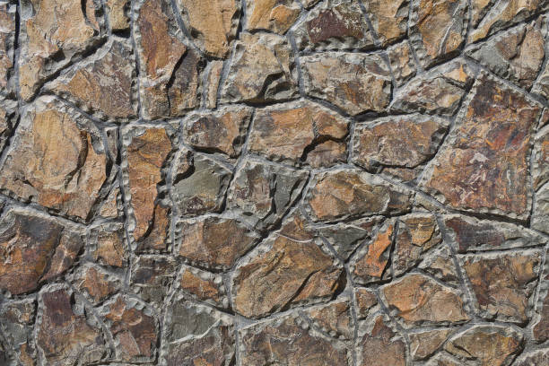 rough-hewn stones closeup background wall of rough-hewn stones closeup roughhewn stock pictures, royalty-free photos & images