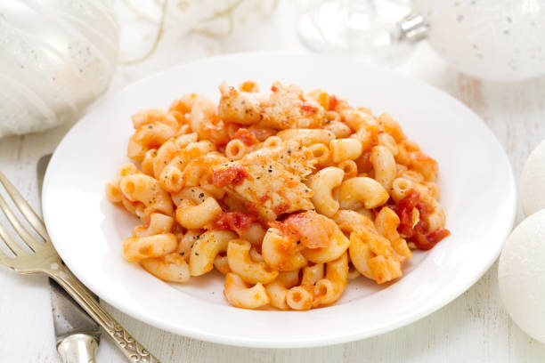 pasta with fish and tomato sauce on white plate