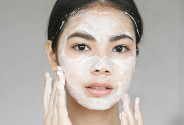 istock Young beautiful woman washing her face with soap. 837403140