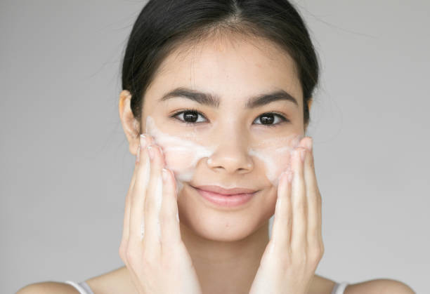 istock Young beautiful woman washing her face with soap. 837403226