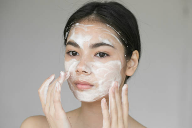 istock Young beautiful woman washing her face with soap. 837403330