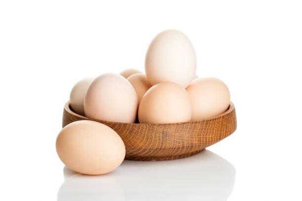 istock chicken eggs in a wooden plate isolated on white background 837411290