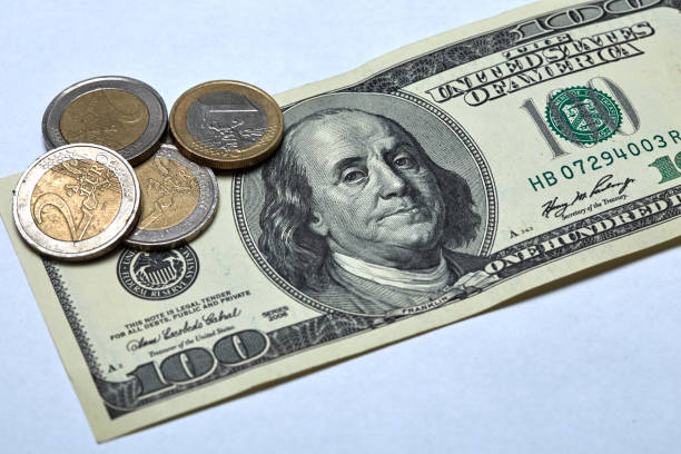 istock One hundred dollar banknote with euro coins 837422878