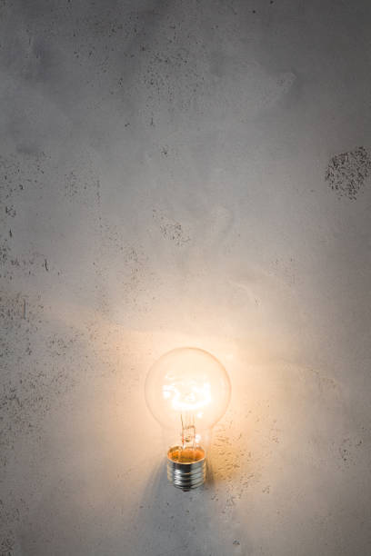istock Vintage incandescent bulb on concrete background 837429260