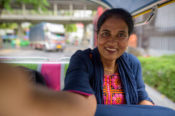 portrait of mature beautiful indian woman riding the tuk tuk around the city of bangkok thailand - siam square imagens e fotografias de stock