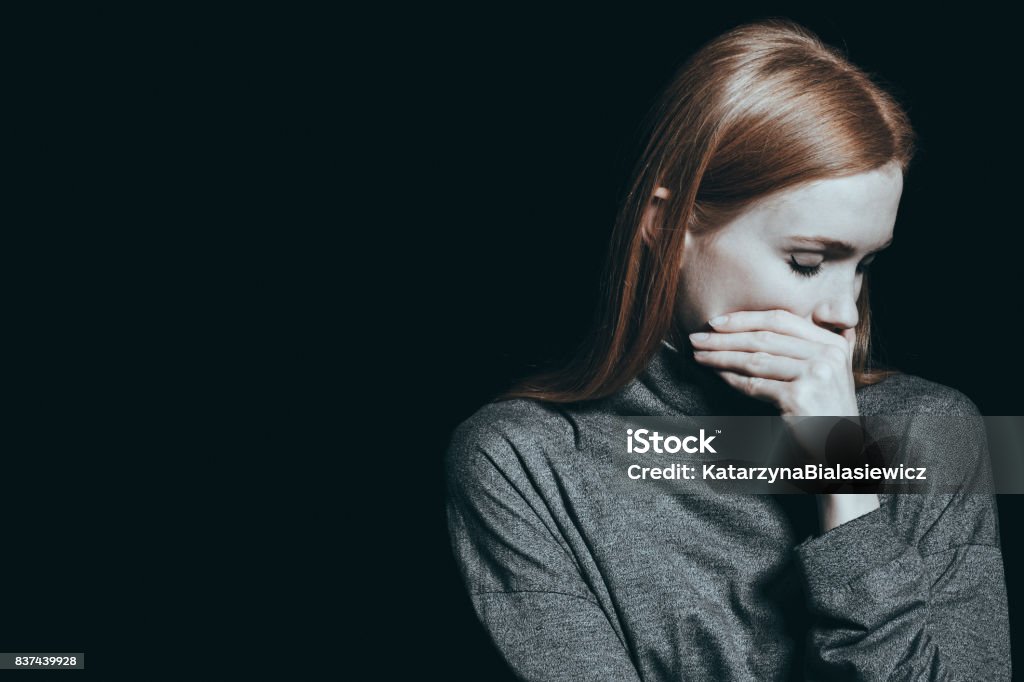 Bulimic woman covering her mouth Bulimic woman covering her mouth, black background Anorexia Nervosa Stock Photo