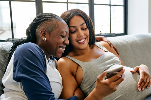 Lesbian couple using smart phone at home