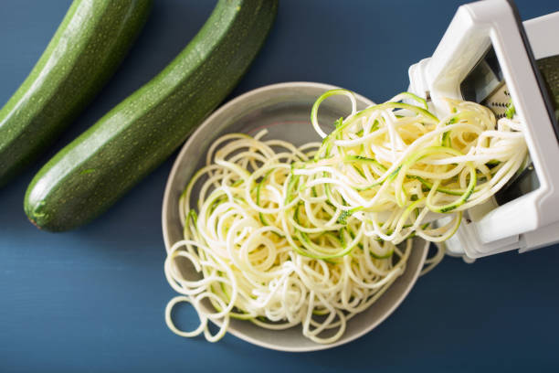 spiralizing vegetal crudo de calabacín con spiralizer - zucchini vegetable squash marrow squash fotografías e imágenes de stock