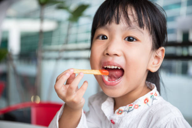 asiática chinês menina comendo batatas fritas - preschooler child chinese ethnicity asian ethnicity - fotografias e filmes do acervo