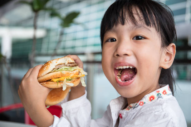 istock Asian Chinese little girl eating burger 837452000