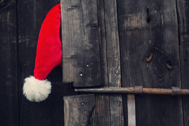 cappello di babbo natale e porta di legno. - barn red old door foto e immagini stock