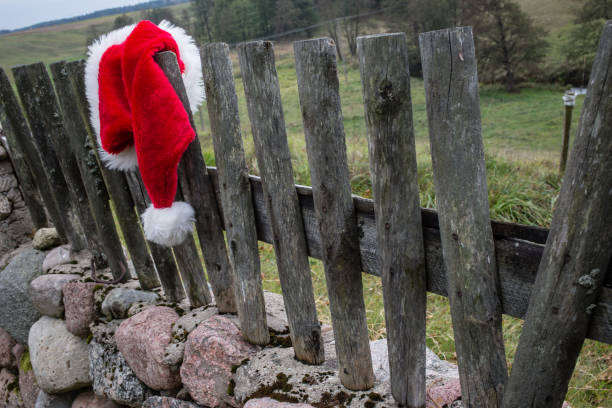 istock Santa Claus hat hanging on the rustic fence. 837452970