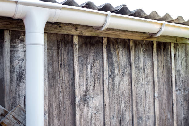 istock New rain gutter on a home against blue sky. New roof. 837461878
