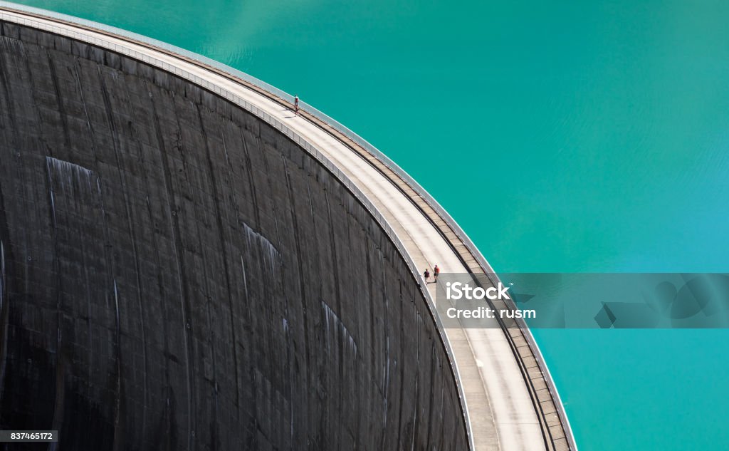 People walking on edge of Stausee Mooserboden Dam, Kaprun, Austria Mooserboden Reservoir, Austria Dam Stock Photo