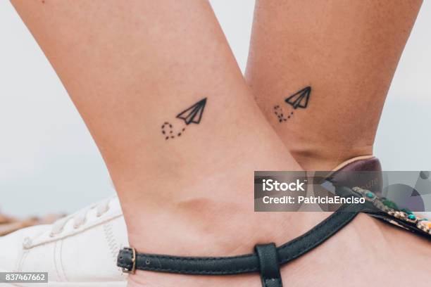 Two Women Having The Same Tattoo Stock Photo - Download Image Now - Tattoo, Friendship, Ankle