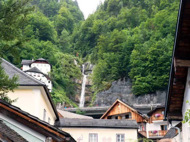 Town Hallstatt with mountain waterfall. Alpine massif, beautiful canyon in Austria. Salzburg Alpine valley in summer, clear water. Destination for vacation, hiking and relaxation.