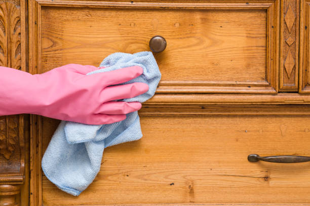 istock Woman's hand in rubber protective glove with microfiber rag cleaning a cupboard in the room. Early spring cleaning or regular clean up. Maid cleans house. 837469316