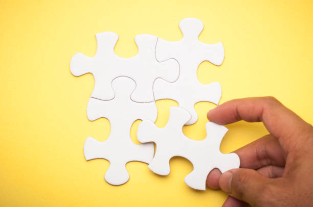 istock Four white puzzle pieces on yellow background. 837469868